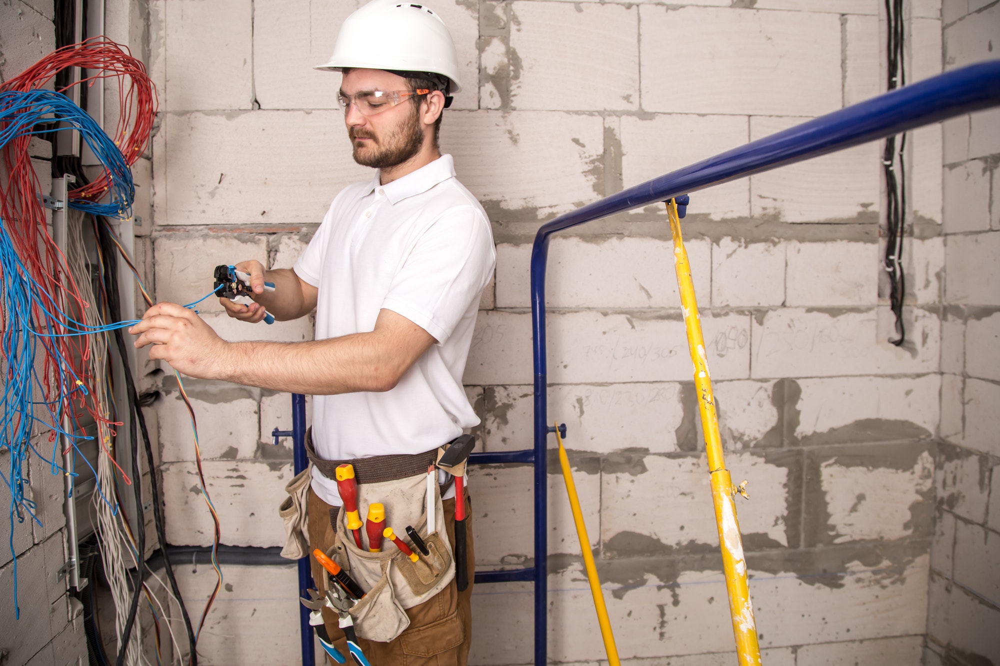 Electrician working near the Board with wires. Installation and connection of electrics.