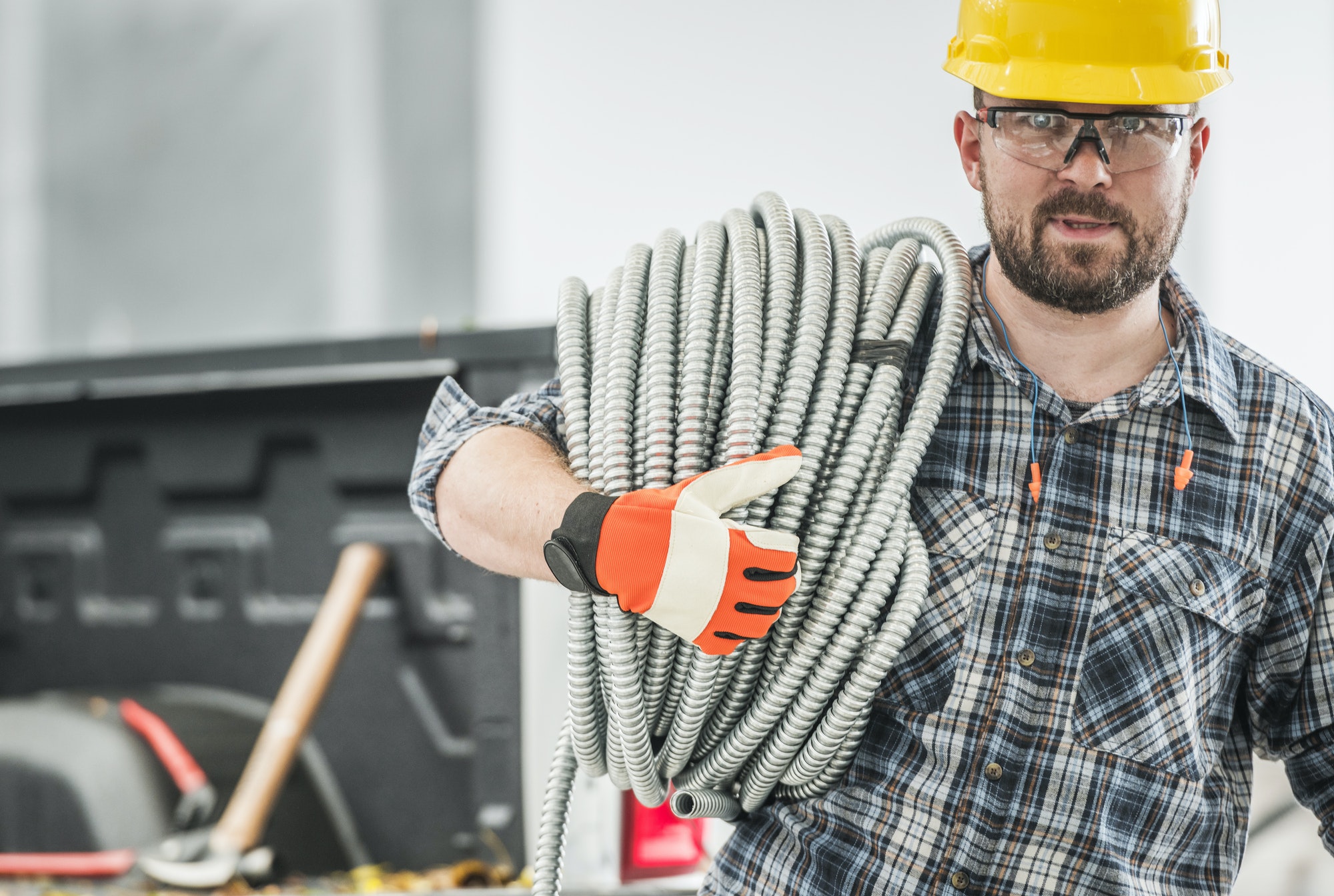 Professional Contractor with Conduit Electric Pipe on His Shoulder