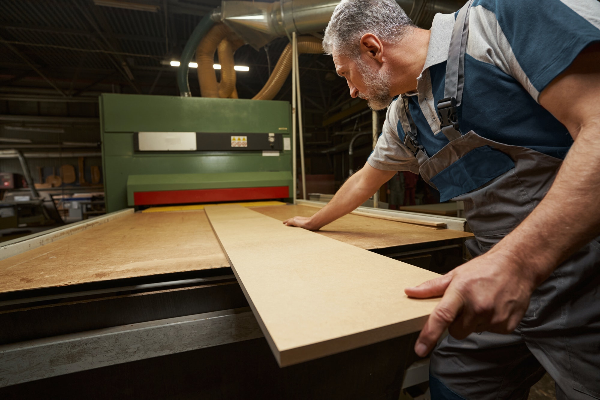 Attentive male person working at woodworking manufacture